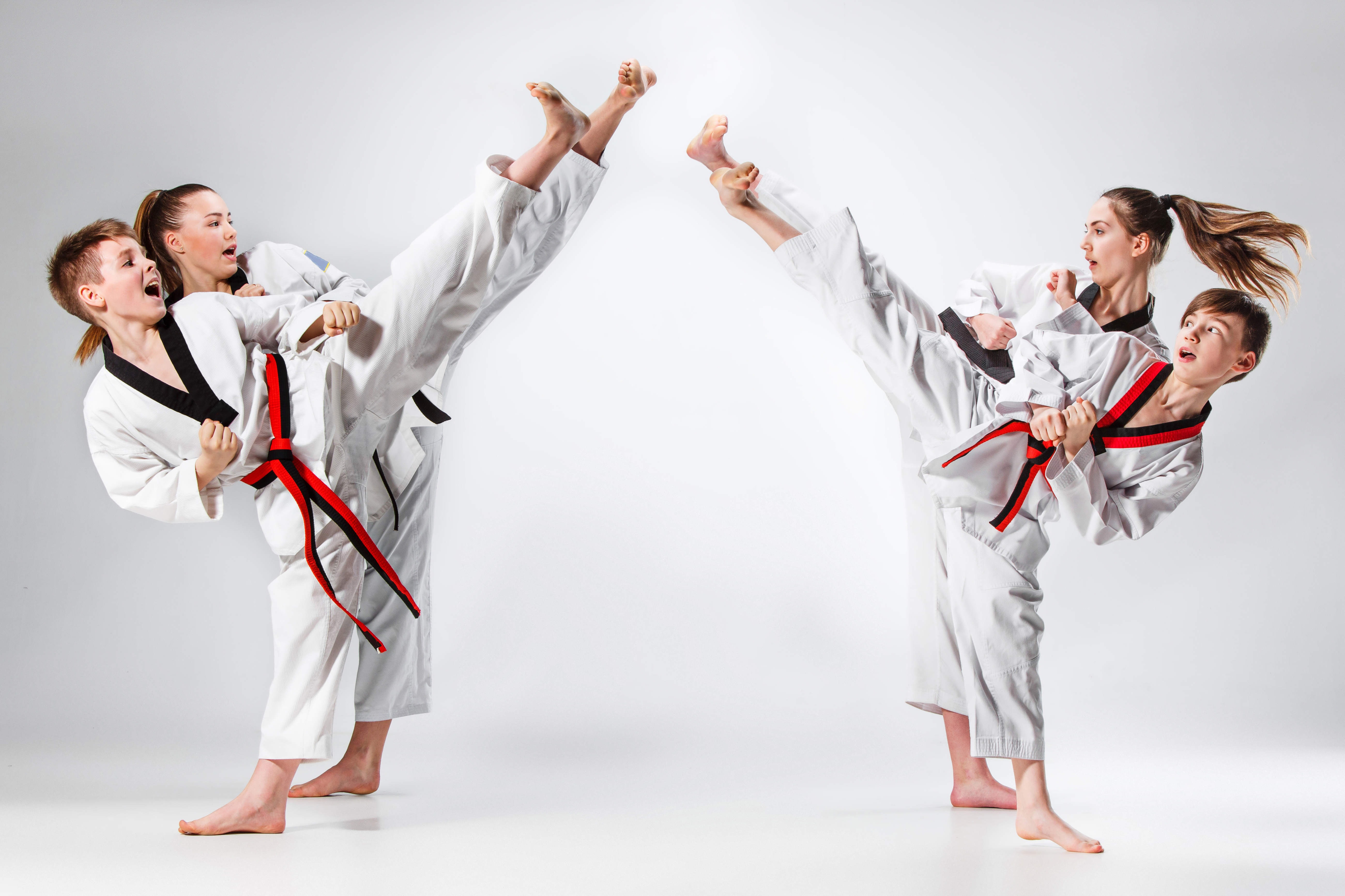 Andy Mole Tae Kwon Do - Tile Image - 4 kids practicing martial arts kicks in the air towards each other