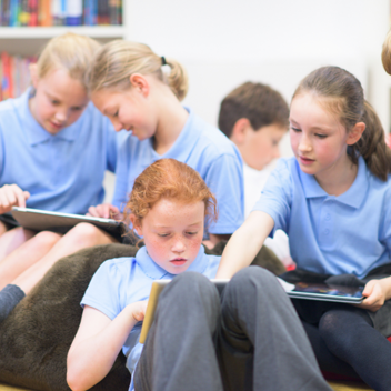 BEN - School Kids sitting in a group looking at tablets and iphones (1)
