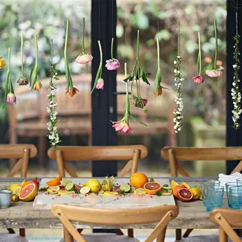 Onkoi - An image of a dressed table with a Flower Curtain And Citrus Fruit getting ready for  a party